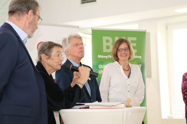 2 Männer 2 Frauen, eine redet in ein Mikrofon